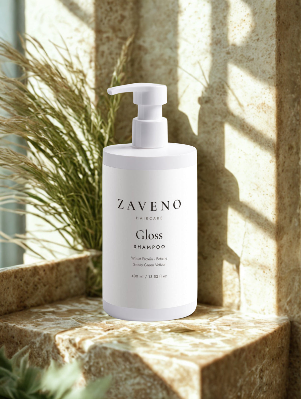 ZAVENO Gloss Shampoo on a stone ledge with vetiver grass