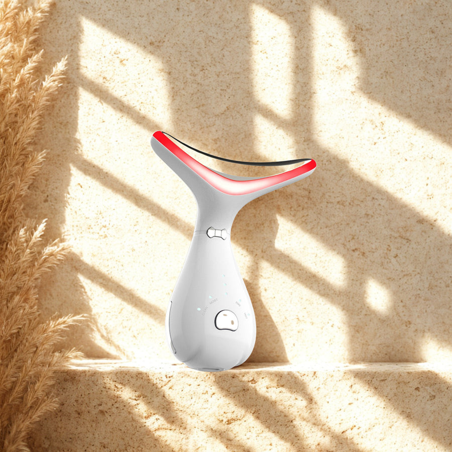 LED Neck Massage Device on a travertine ledge in warm window light