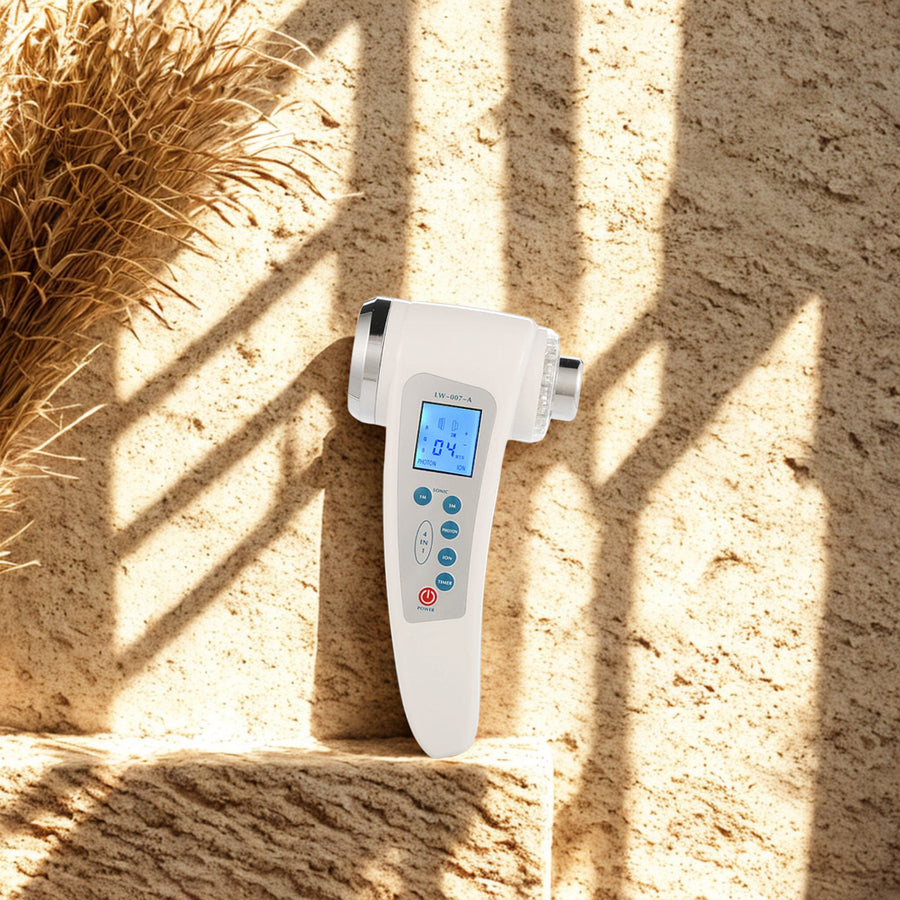 Ultrasonic Facial Device on a travertine ledge in warm window light